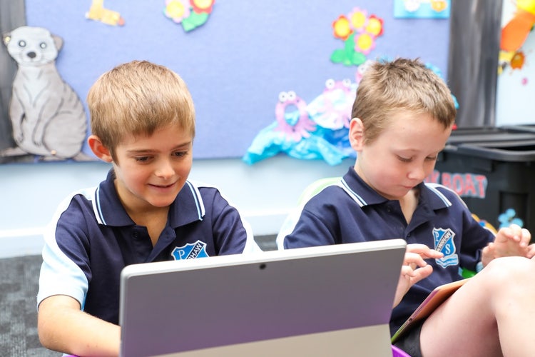 Two students working on digtal devices