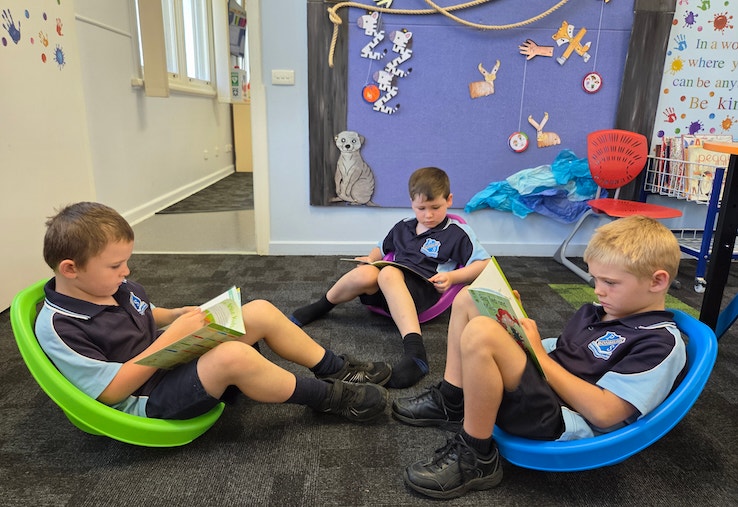 Image of three students reading in a calm and quiet zone in the classroom