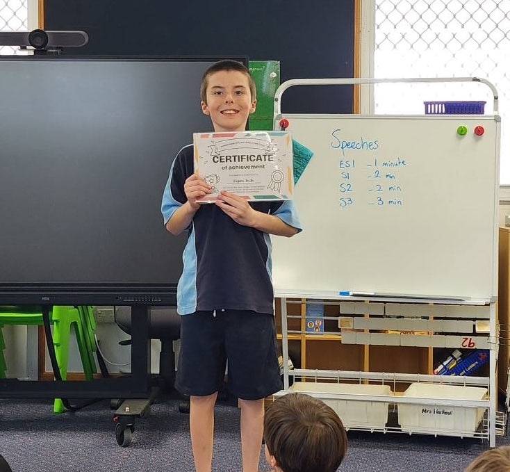 Image of student with an achievement certificate for public speaking